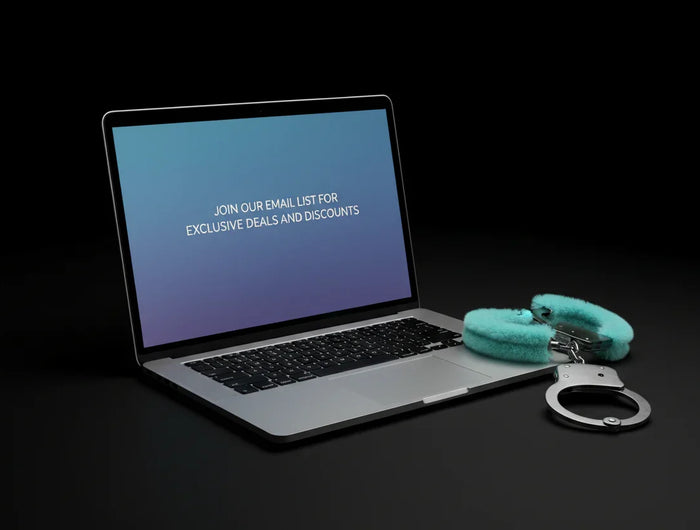 black background with a silver laptop that says "join our email list for exclusive deals and discounts". Next to the laptop is a pair of fuzzy aqua blue handcuffs